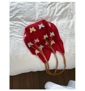 Détails du sac fourre-tout en crochet rouge avec broderies de papillons et perles blanches