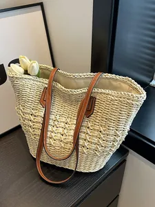 Handwoven straw tote bag with brown leather straps and interior lining for summer