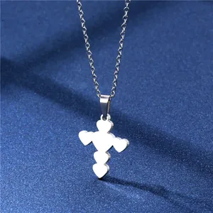 Minimalistisches silbernes Herz-Kreuz-Halsketten-Set auf blauem strukturiertem Stoff