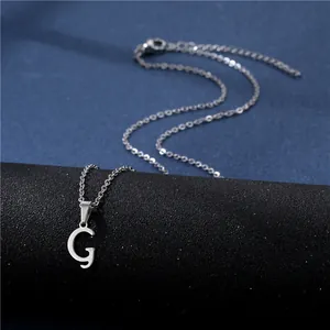 Detailed view of polished letter G pendant on stainless steel chain with lobster clasp