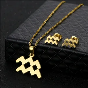 Set di collana e orecchini Aquarius dorati minimalisti su una scatola di gioielli nera