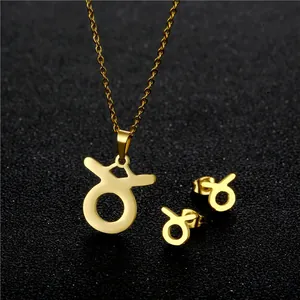 Dettaglio del set collana e orecchini segno zodiacale Toro in oro su sfondo glitterato nero