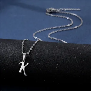 Polished silver stainless steel letter K pendant on a fine chain over a dark backdrop