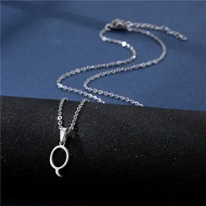 Macro detail of silver polished letter Q pendant on a stainless steel cross chain