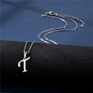 Polished silver cursive letter T pendant necklace on a sleek black display stand