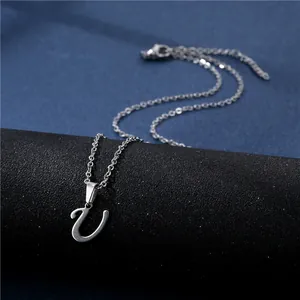 Close-up of a silver stainless steel necklace with a cursive U letter pendant