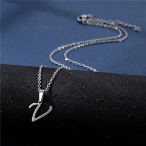 Macro shot of silver-colored letter V pendant with a polished brush texture on a chain