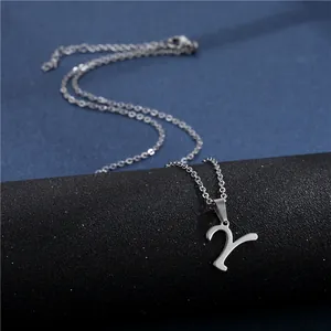 Detailed view of silver stainless steel cursive letter Y pendant necklace on a jewelry stand