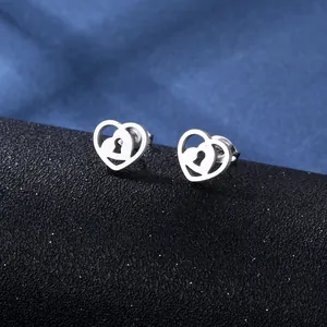 Polished stainless steel double heart stud earrings with keyhole detail on black base