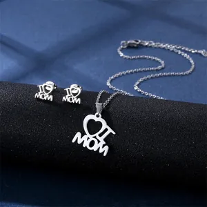 Silver I Love Mama necklace and earrings set displayed on a stylish jewelry stand