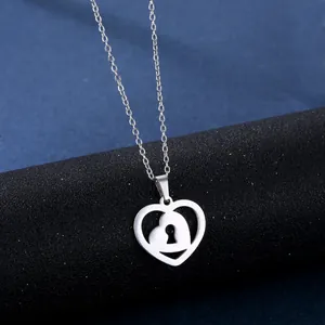 Polished stainless steel heart lock pendant necklace on a textured black stand