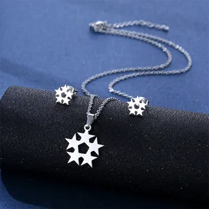 Silver stainless steel star necklace and earrings set on a dark textured display
