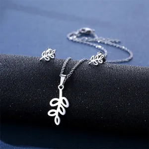 Silver leaf pendant necklace and earrings set displayed on a dark blue jewelry roll