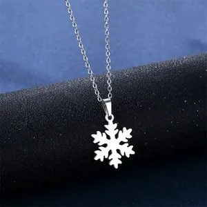 Silver snowflake pendant necklace with delicate chain on a sleek dark pedestal