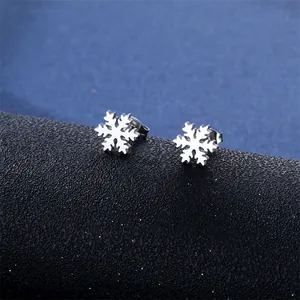 Polished stainless steel snowflake stud earrings with hollow design on black display