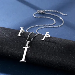 Details des silbernen Schmucksets mit Buchstabe I Halskette und Ohrsteckern auf Podest