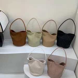 Woven leather hobo shoulder bags in six colors displayed on a white tiered stand