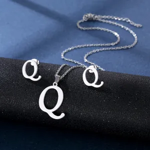 Nahaufnahme von silbernem Edelstahl Q-Buchstaben Halsketten und Ohrring Set auf Ständer
