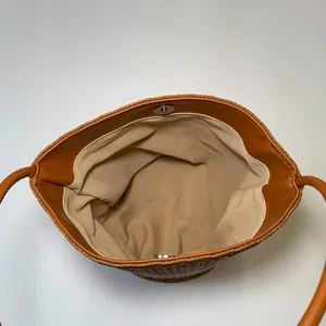 Detailed close-up of brown woven tote bag interior with magnetic snap closure