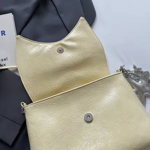 Detailansicht der gelben Lackledertasche mit Katzenohr-Klappe und Seestern-Metallanhänger