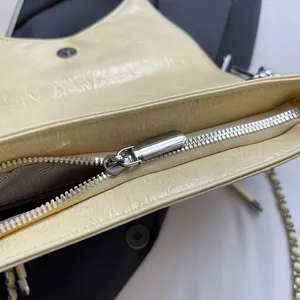 Detailansicht der cremefarbenen Ledertasche mit Silber-Reißverschluss und Magnetschnalle