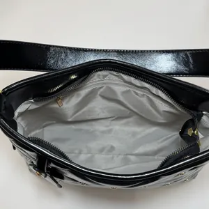 Inside view of black quilted faux leather shoulder bag with gold hardware and lining