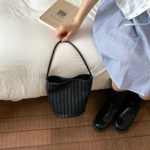 Close-up of black woven texture on a minimalist bucket bag for a trendy aesthetic