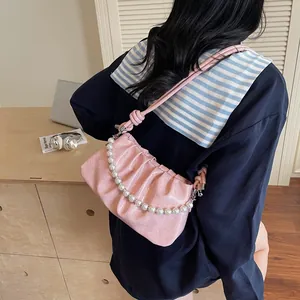 Detail of pink pleated shoulder bag with pearl metal chain and glossy texture