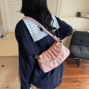 Pink pleated underarm bag with glossy finish and decorative pearl chain strap