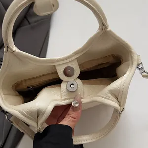 Dettaglio borsa a secchiello in pelle martellata con chiusura magnetica e tasca interna