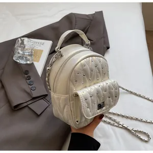 Detail of rhinestone mini backpack with pearl white leather and silver chain strap