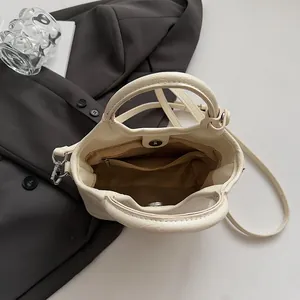 Vista dall'alto della borsa a secchiello crema con fodera interna e tasca con zip e chiusura