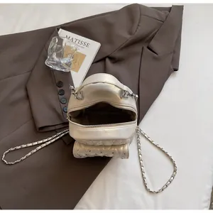 Top view of cream white quilted chain bag with rhinestone details and inner compartment