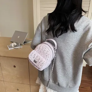 Detailed back view of pink quilted mini backpack with rhinestones and silver chains