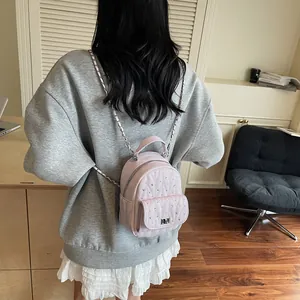 Detail of pink quilted mini backpack with rhinestone studs and silver chain strap