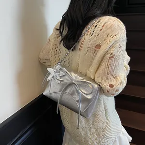 Silberne Kettenschultertasche mit großer Schleife und Sternanhänger auf Metallic-Leder