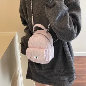 Detail of pink rhinestone mini backpack with diamond quilting and chain strap