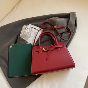 Vue détaillée du sac cabas en cuir rouge avec bandoulière et tablette pour référence