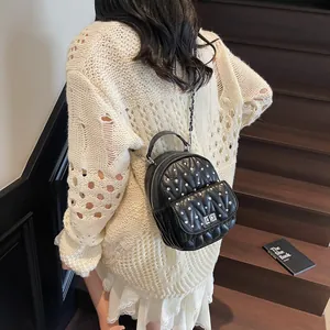 Detail of black quilted mini backpack with rhinestone studs and chain shoulder strap
