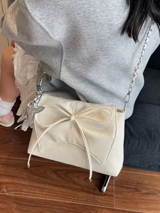 Schicke cremefarbene Ledertasche mit Schleife und silbernem Sternanhänger crossbody