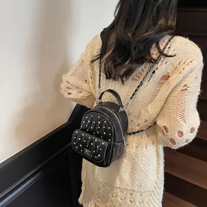 Detail of black mini rhinestone backpack with chain strap and V-shaped quilting