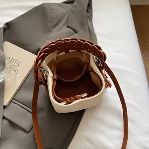 Detail view of canvas bucket bag interior with leather braided handle and adjustable strap