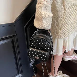 Detail of silver rhinestone embellishments and diamond quilting on black mini backpack