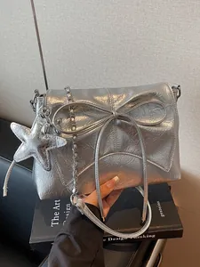 Metallisch silberne Umhängetasche mit großer Schleife, Kette und Seestern-Anhänger