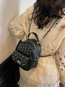 Mini black rhinestone backpack with quilted pattern and chain straps on model