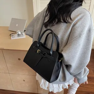 Sac fourre-tout pratique en cuir noir présenté dans une scène de travail avec ordinateur