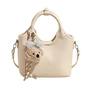 Elegante cremeweiße Beuteltasche mit festem Griff und süßem Plüsch-Hundeanhänger