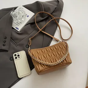 Détail du sac seau matelassé caramel avec chaîne en métal et fine bandoulière en cuir
