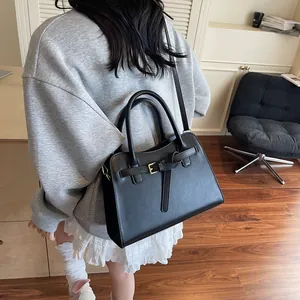 Détail d'un grand sac cabas noir en cuir PU avec boucles dorées et bandoulière fine