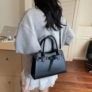 Gros plan d'un sac cabas en cuir noir avec ferrures dorées et bandoulière pour le travail